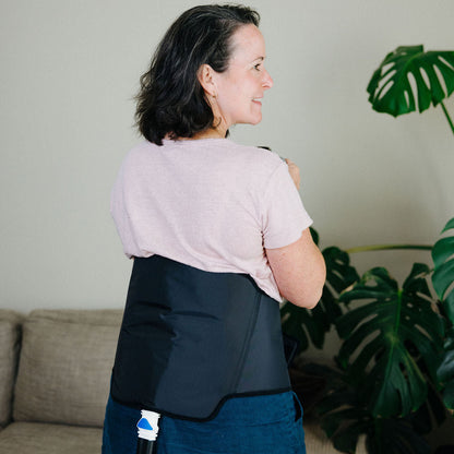 Woman standing in a room wearing back cuff