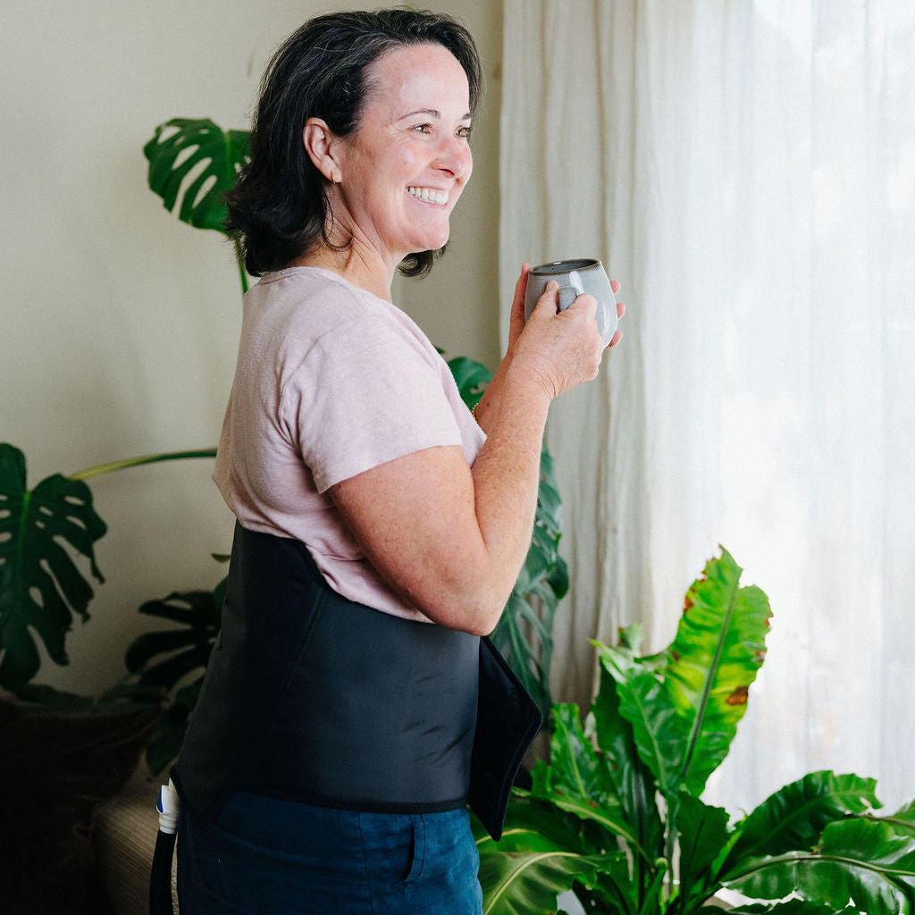 Woman drinking tea and smiling wearing back cuff