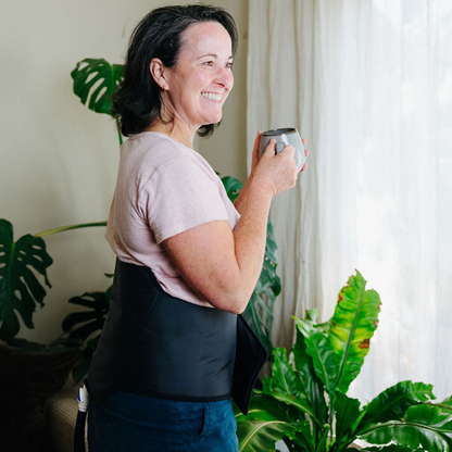 Woman drinking tea and smiling wearing back cuff