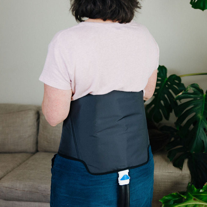 Woman standing in room wearing back cuff