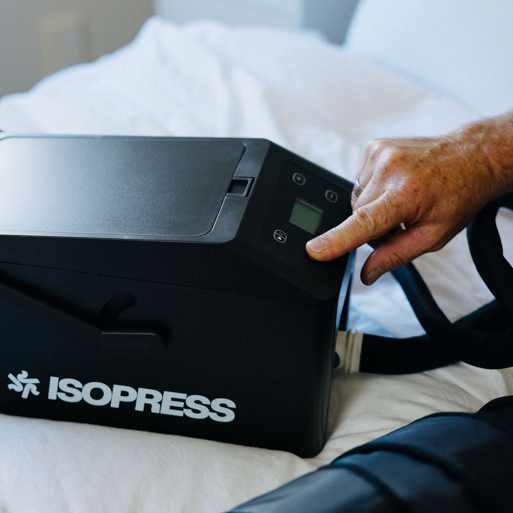 Person using an ISOPRESS device on a bed